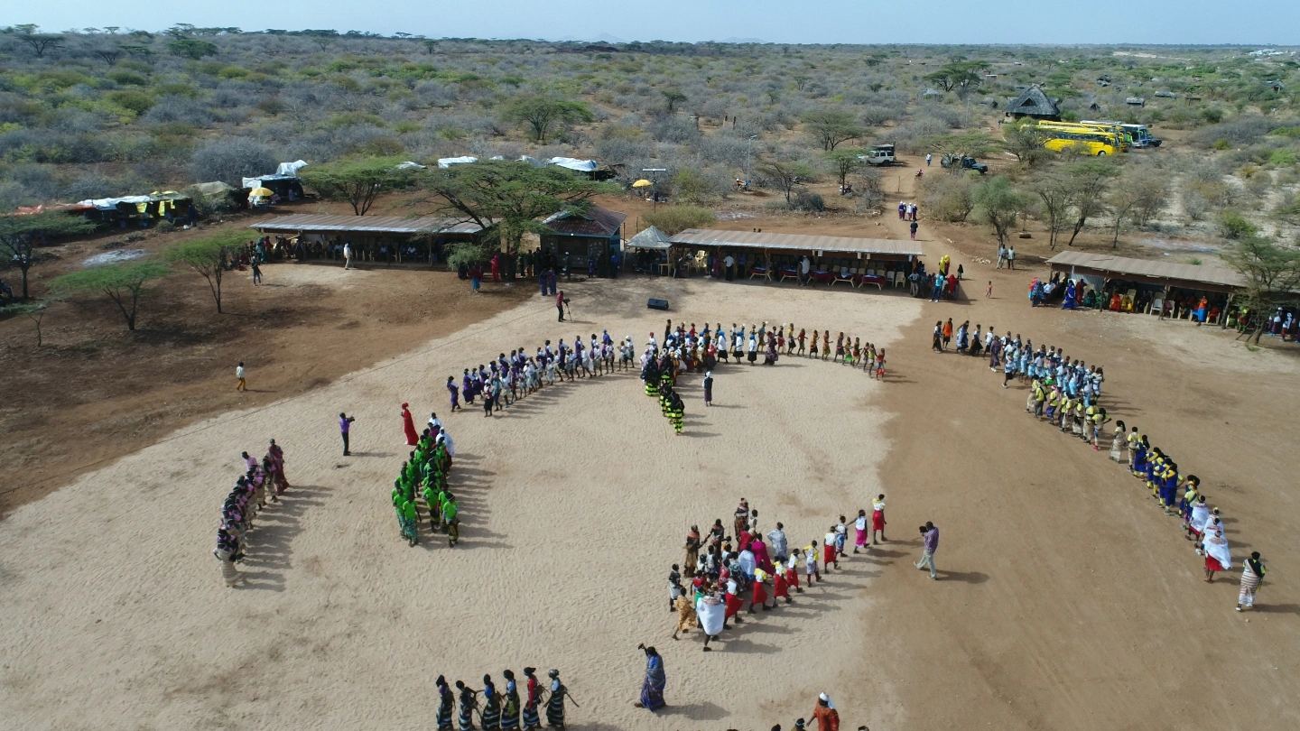 Aerial view of dancers forming a circle at a cultural celebration.