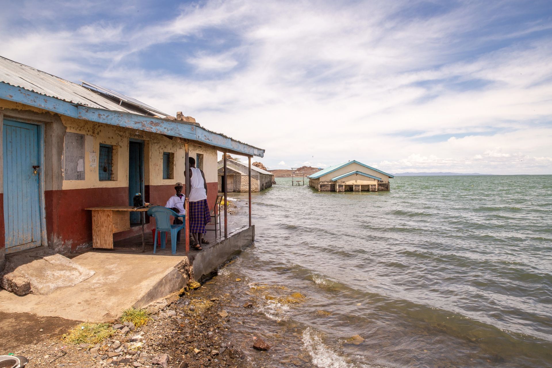 Rising lake waters reach the walls of a lakeside building, a reminder of changing landscapes.