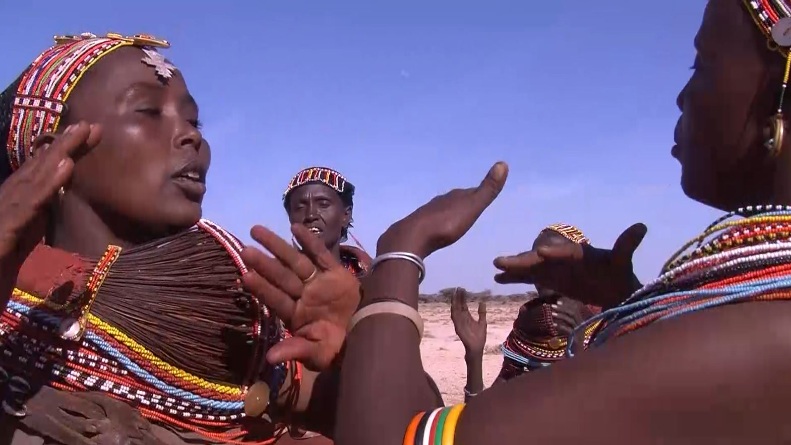 Women in traditional dress line up for a festival performance.