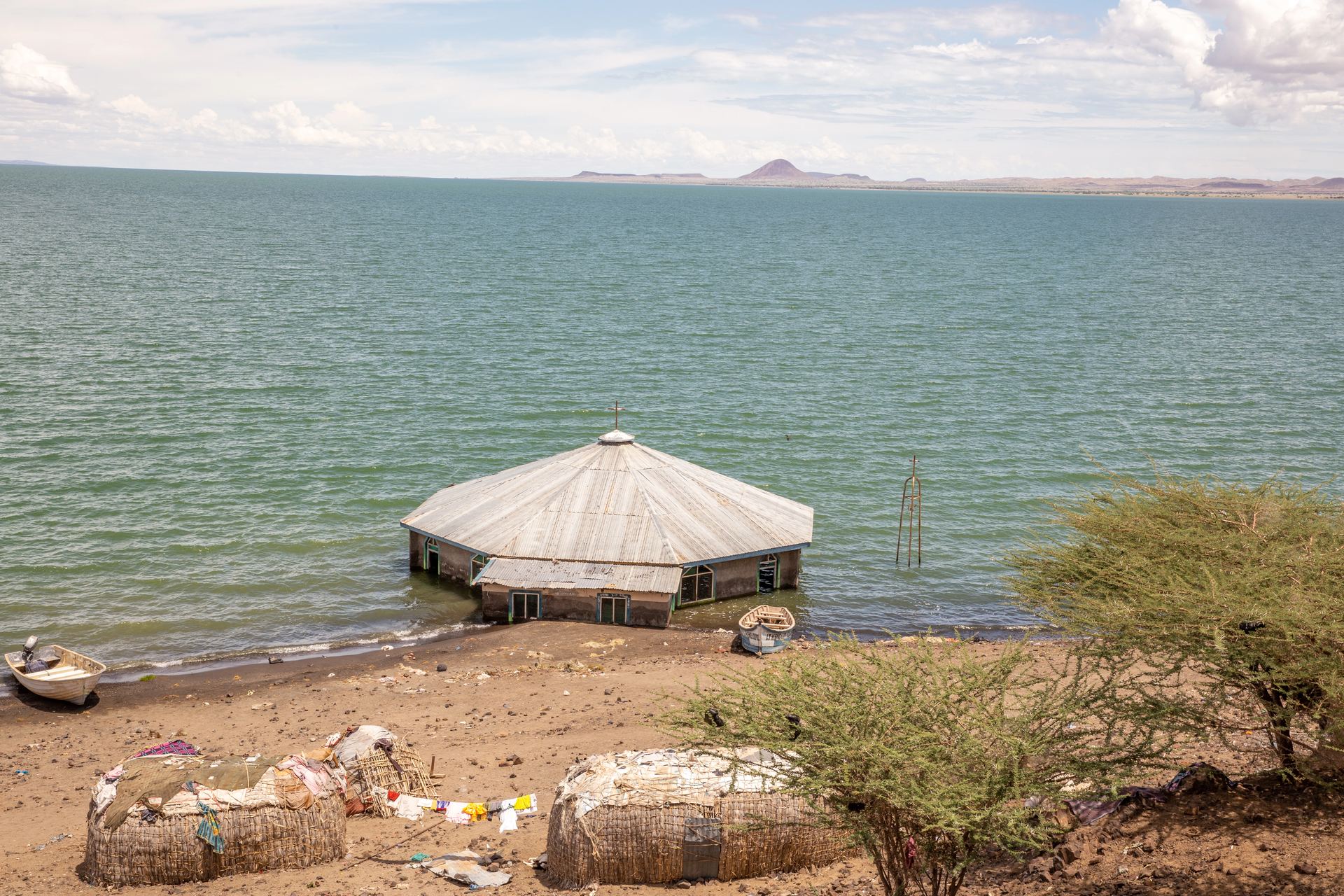 A thatched round hut on the shore of a Northern Kenya lake.